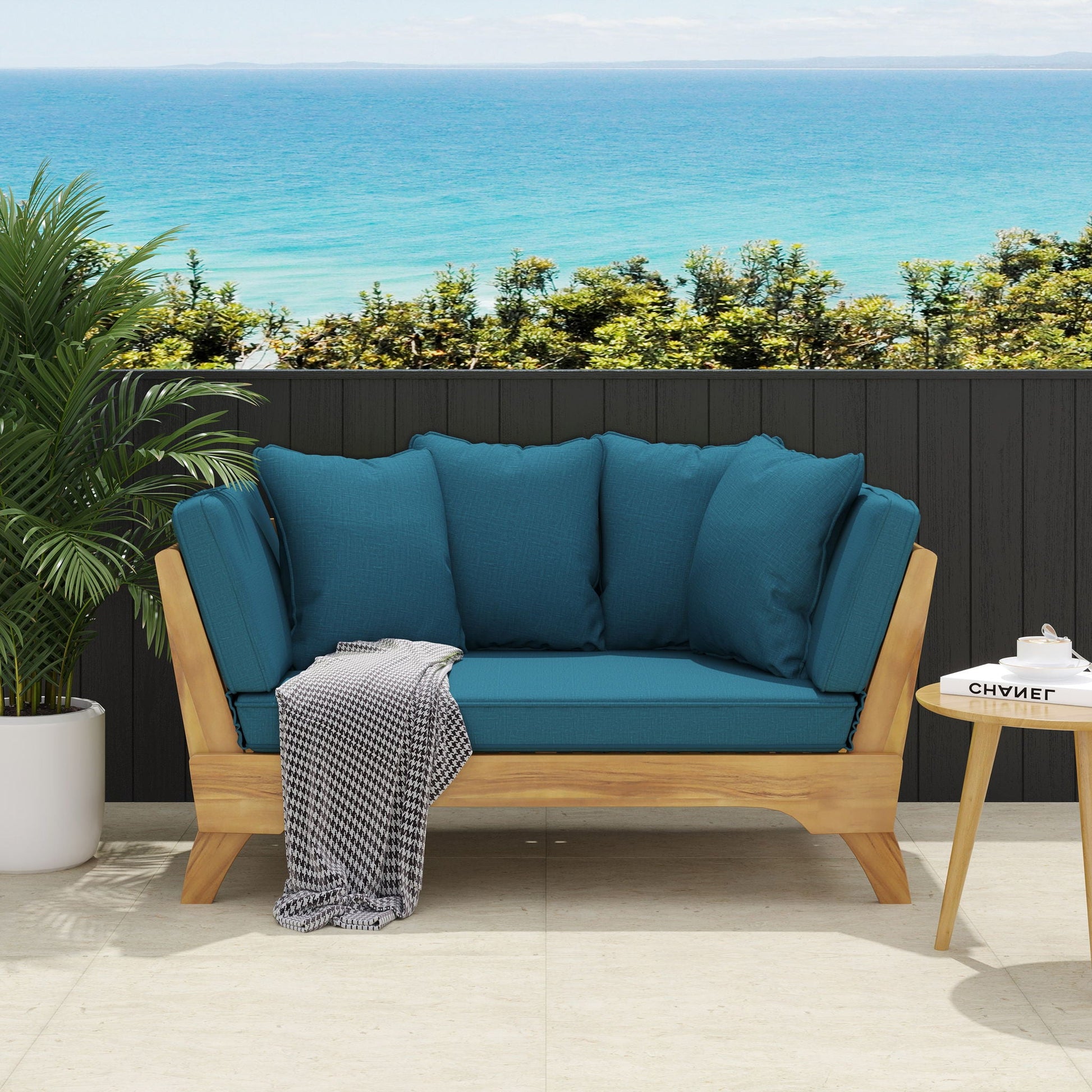 Blue outdoor sofa with wooden frame against a scenic ocean backdrop