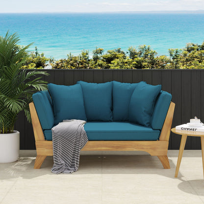Blue outdoor sofa with wooden frame against a scenic ocean backdrop