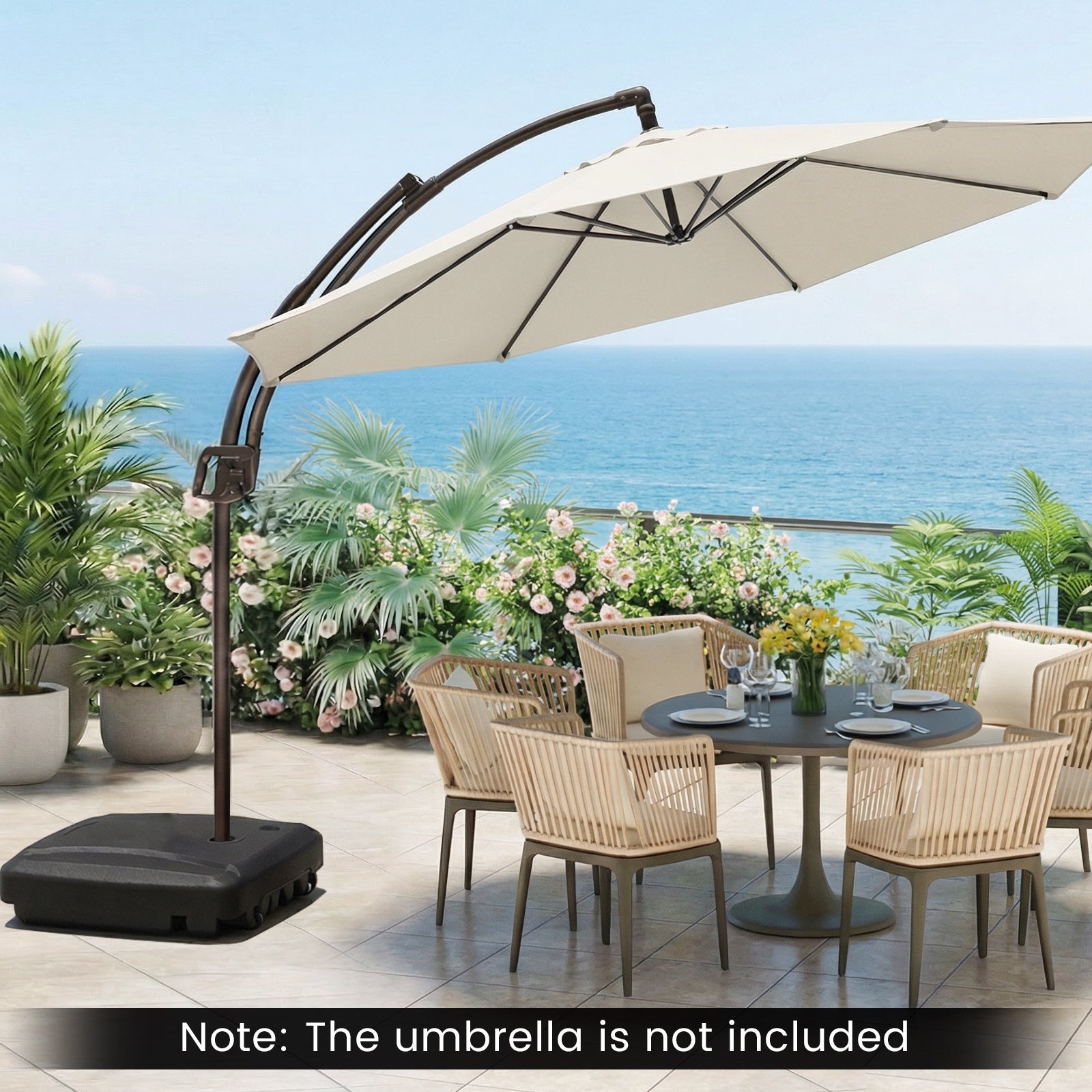 Outdoor patio set with table, chairs, and umbrella stand by the ocean.