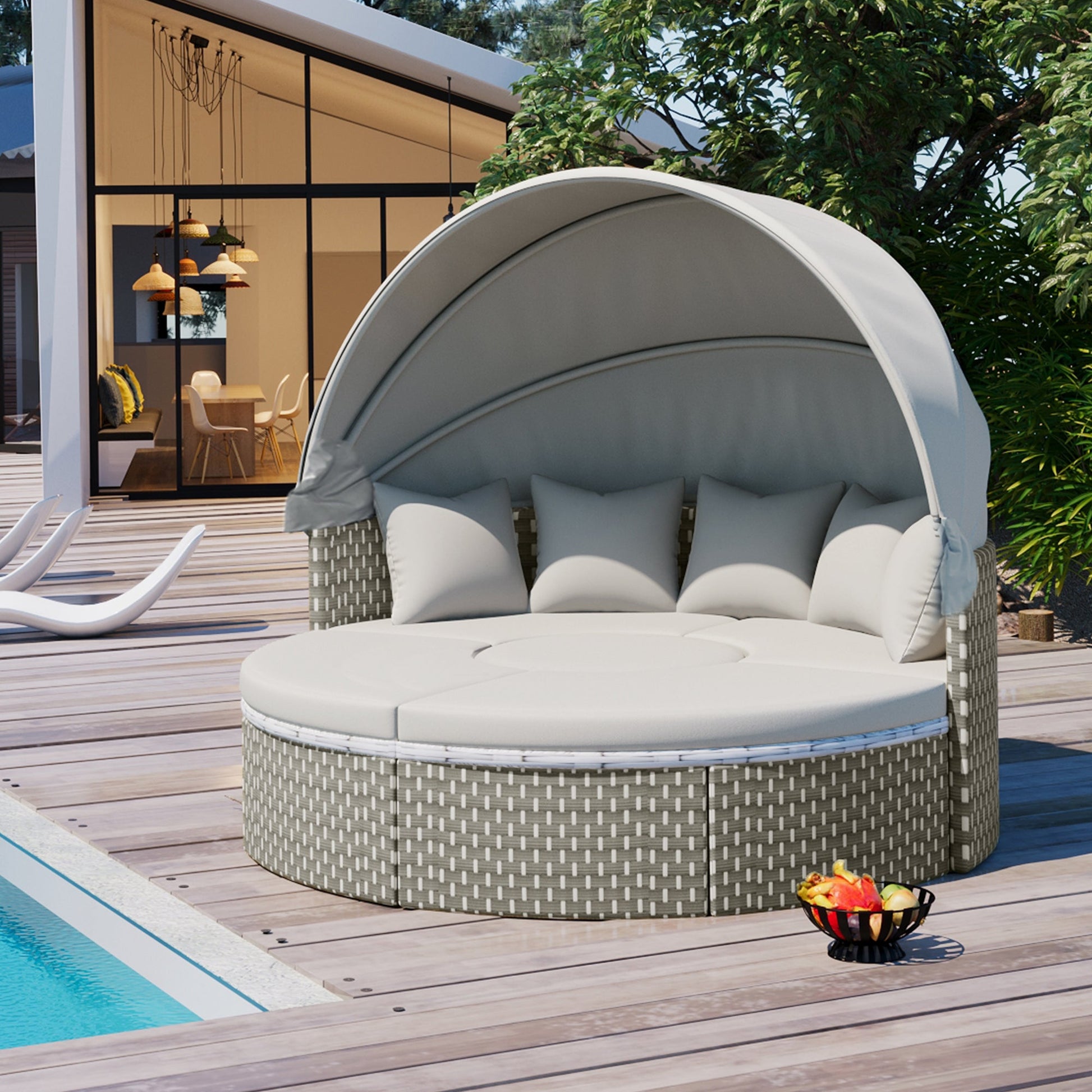 Round outdoor daybed with canopy on a wooden deck by a pool