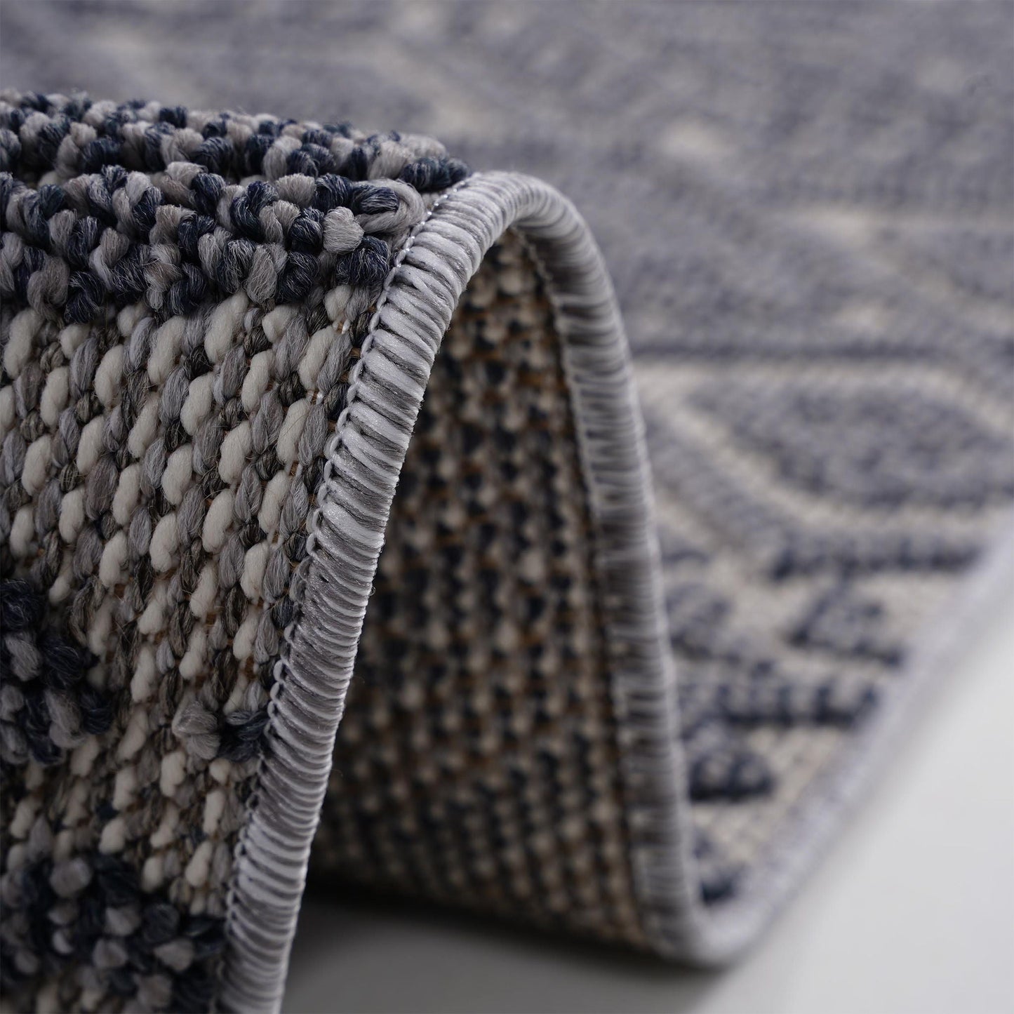 Close-up of a textured rug with a focus on the pattern and edge.