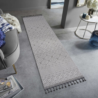 Long rectangular rug with a geometric pattern on a gray floor in a living room setting.