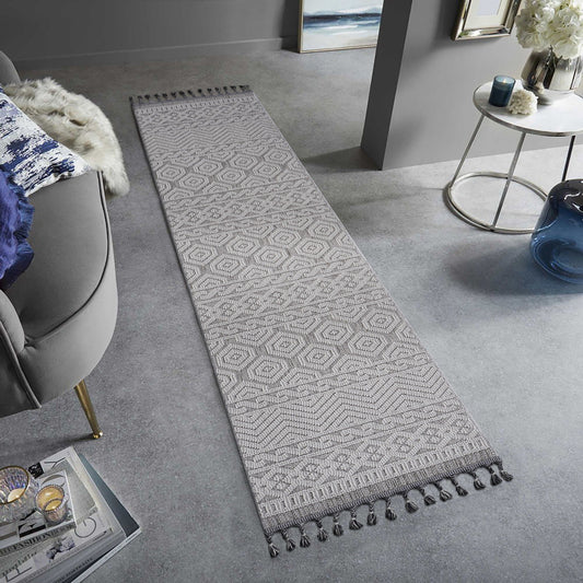 Long rectangular rug with a geometric pattern on a gray floor in a living room setting.