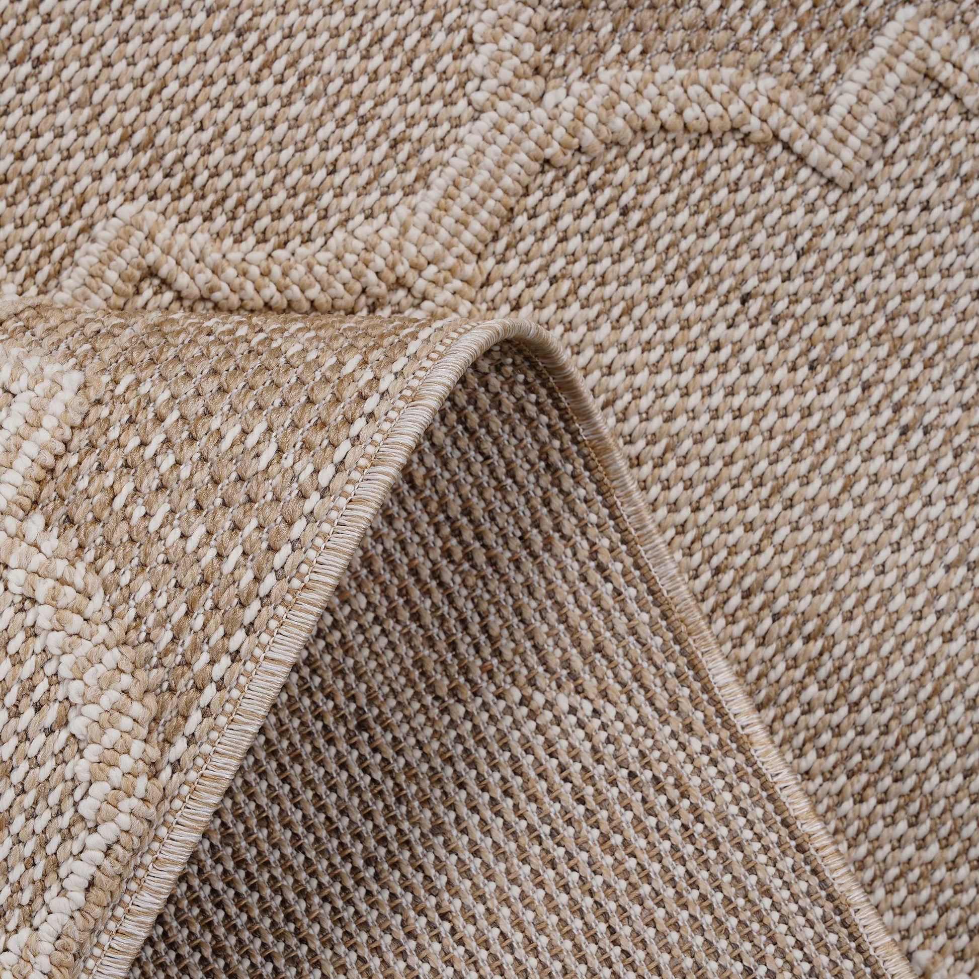 Close-up of a textured beige carpet with a subtle pattern
