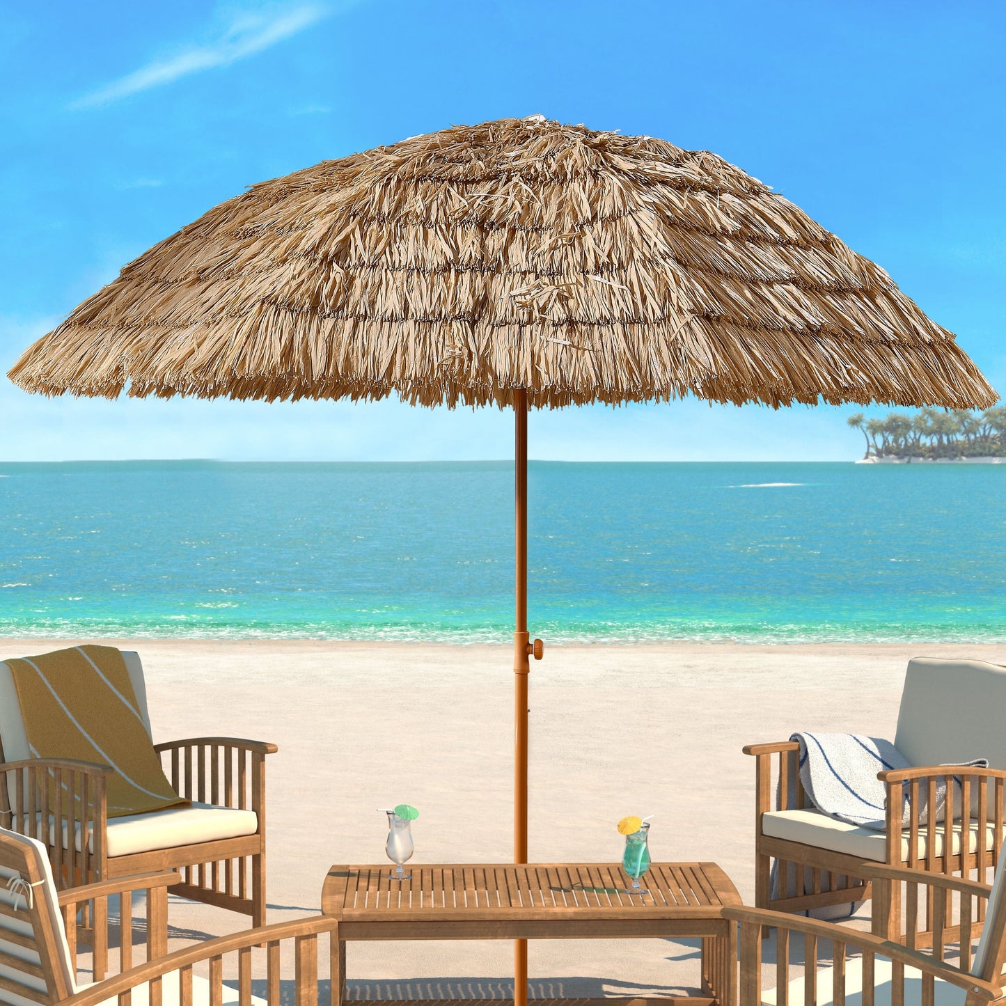 Beach scene with thatched umbrella, chairs, and table by the ocean