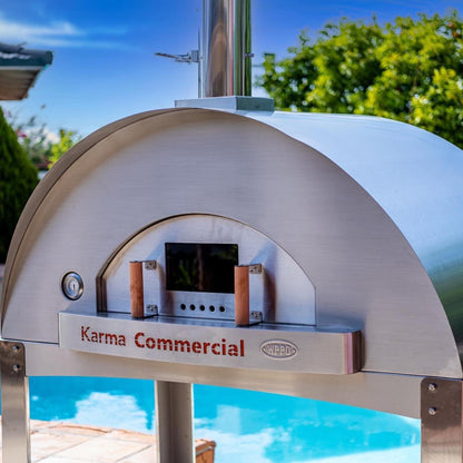 Karma Commercial pizza oven outdoors with pool and trees in the background