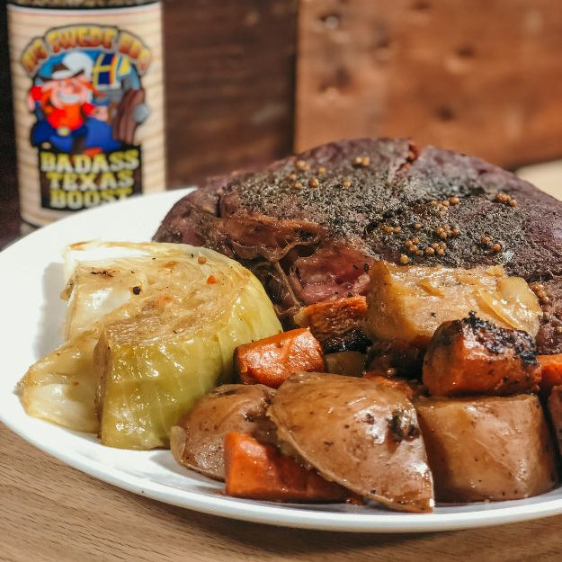 Plated barbecue meal with vegetables and a jar of seasoning on a wooden background