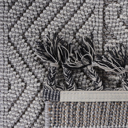 Close-up of a textured gray rug with tassels