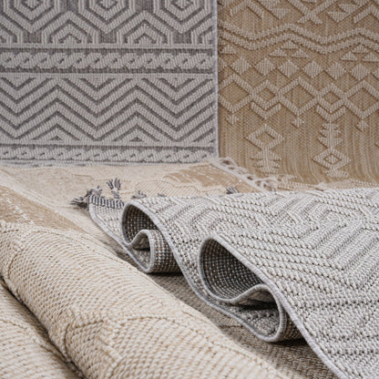 Rolls of patterned rugs in various colors on a neutral background