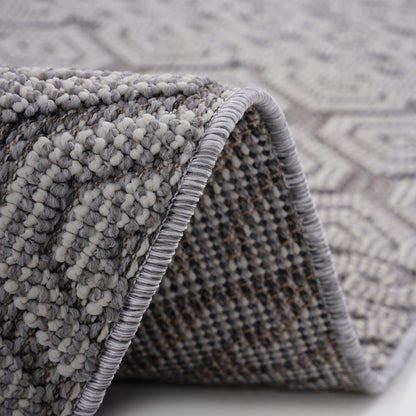 Close-up of a textured gray rug with a geometric pattern.