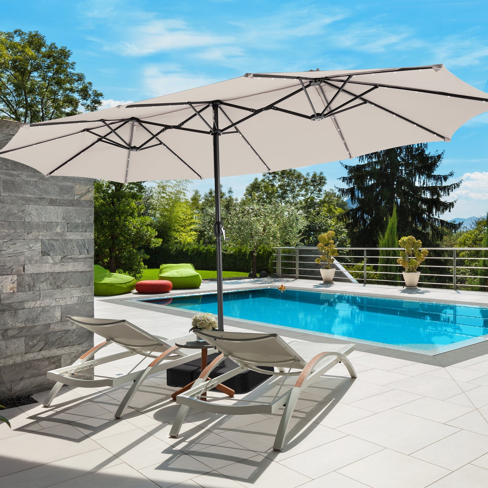 Beige patio umbrella over lounge chairs by a pool with a scenic background