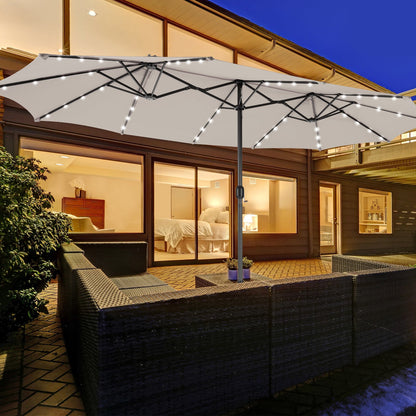 Large patio umbrella with LED lights over a outdoor seating area at night.