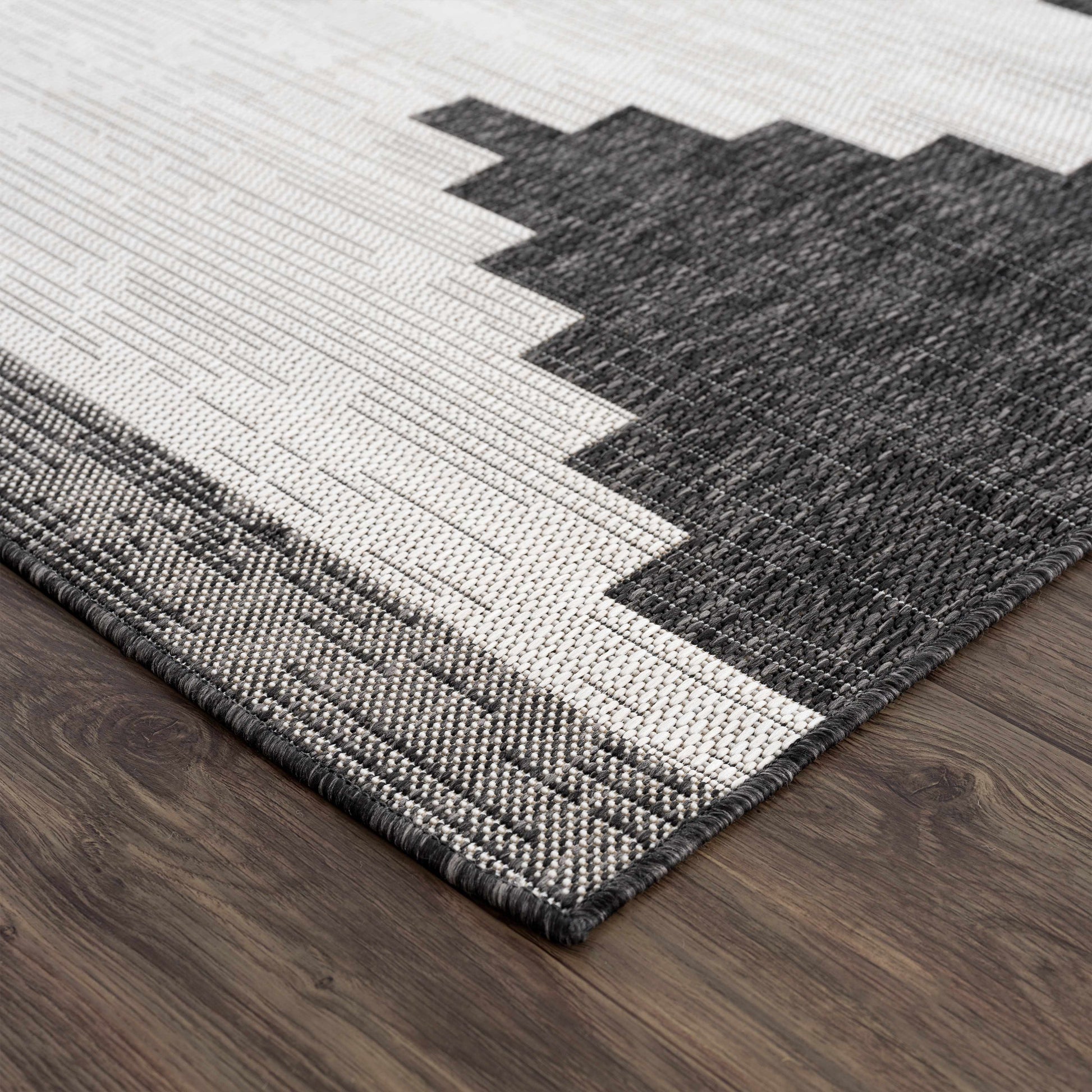 Gray and white geometric patterned rug on a wooden floor