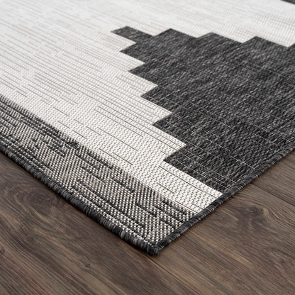 Gray and white geometric patterned rug on a wooden floor