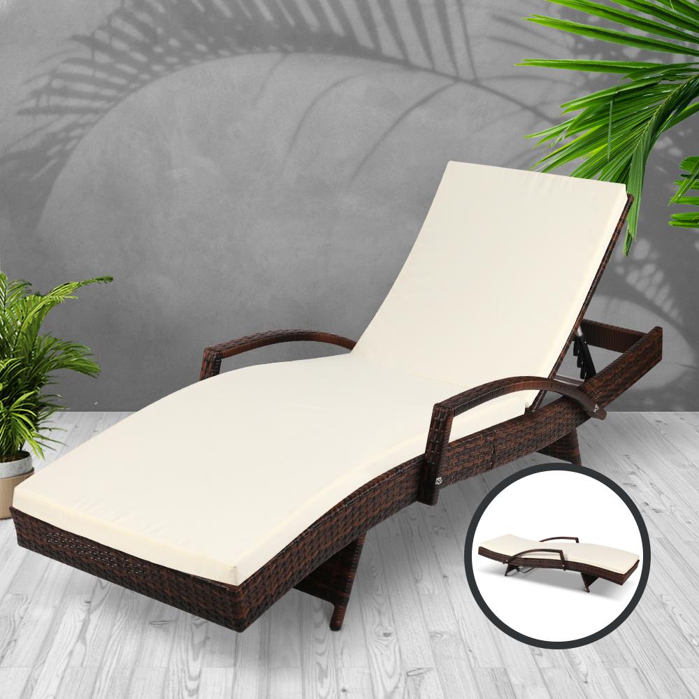 Brown wicker sun lounger with beige cushion on a gray background