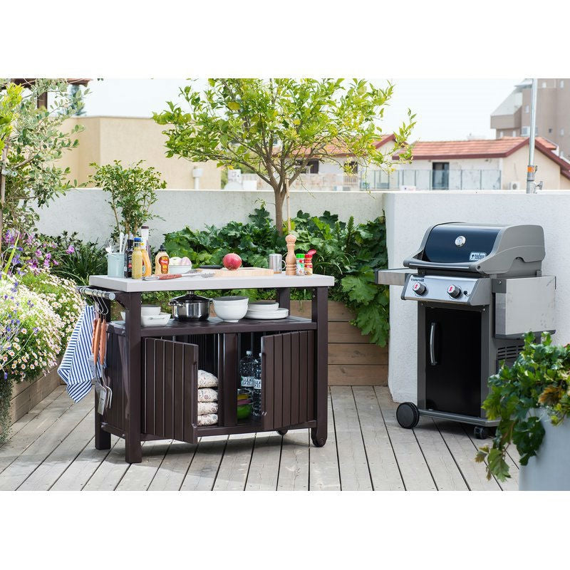 Outdoor kitchen setup with a grill and prep table on a wooden deck.