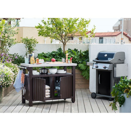 Outdoor kitchen setup with a grill and prep table on a wooden deck.