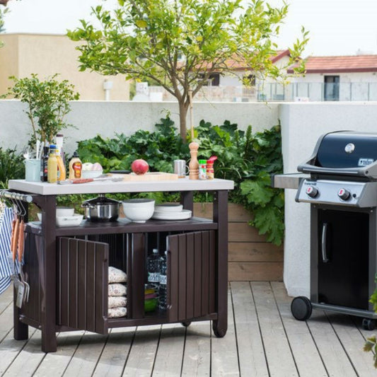 Outdoor kitchen setup with a grill and prep table on a wooden deck.