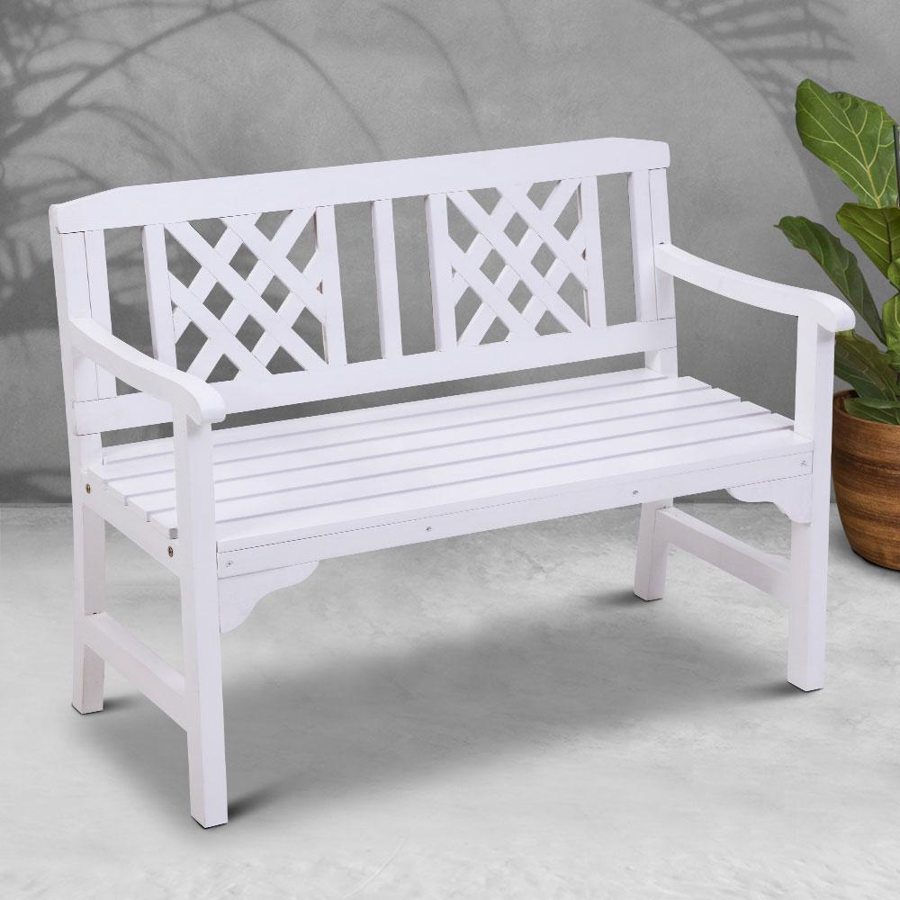 White wooden bench with lattice backrest on a light gray surface.