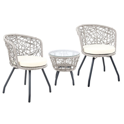 Two wicker chairs with white cushions and a matching table on a white background