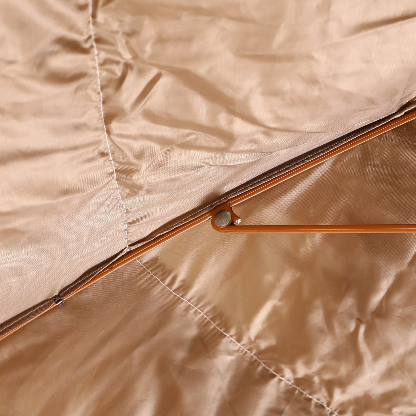 Close-up of beige fabric with a metal rod running through it
