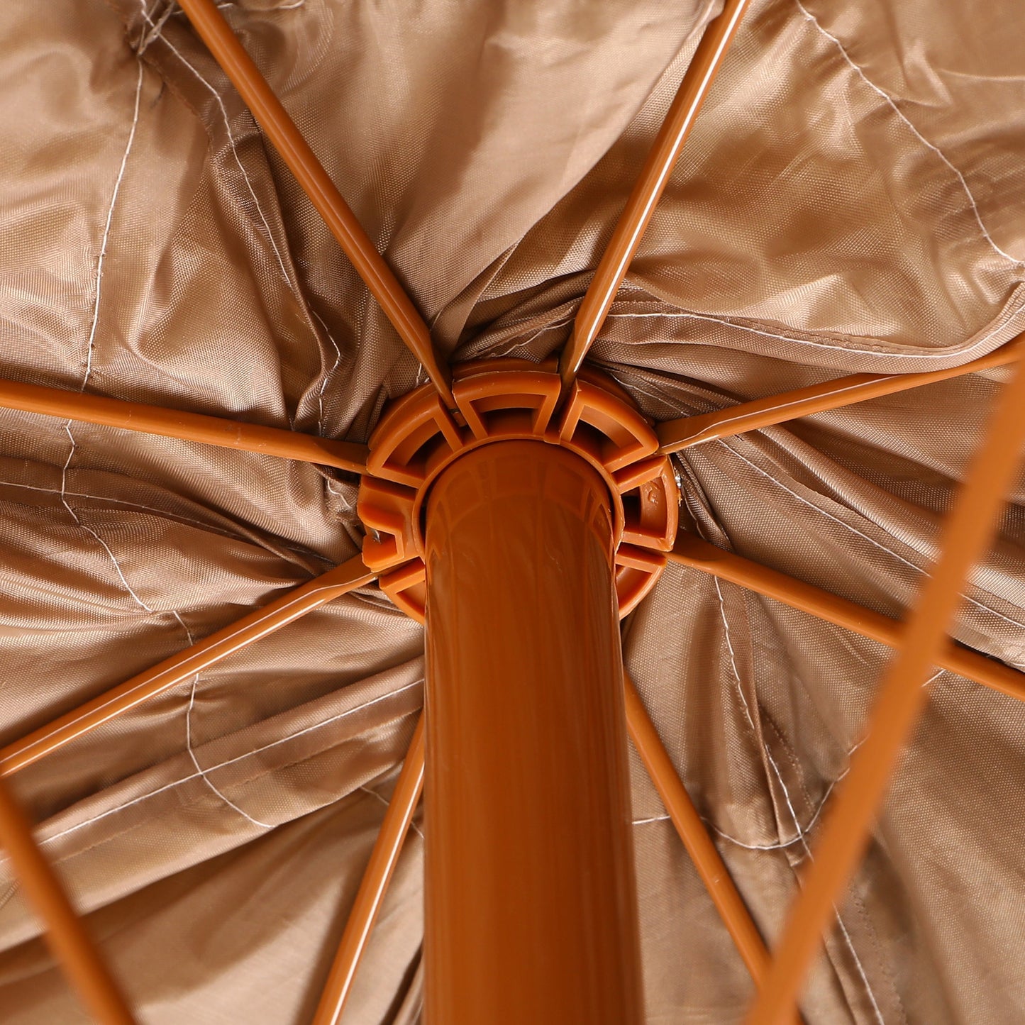 Close-up of an open umbrella with a brown fabric and wooden frame.