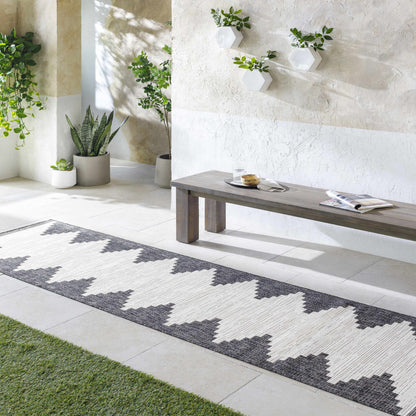 Patterned rug on a patio with a bench and plants