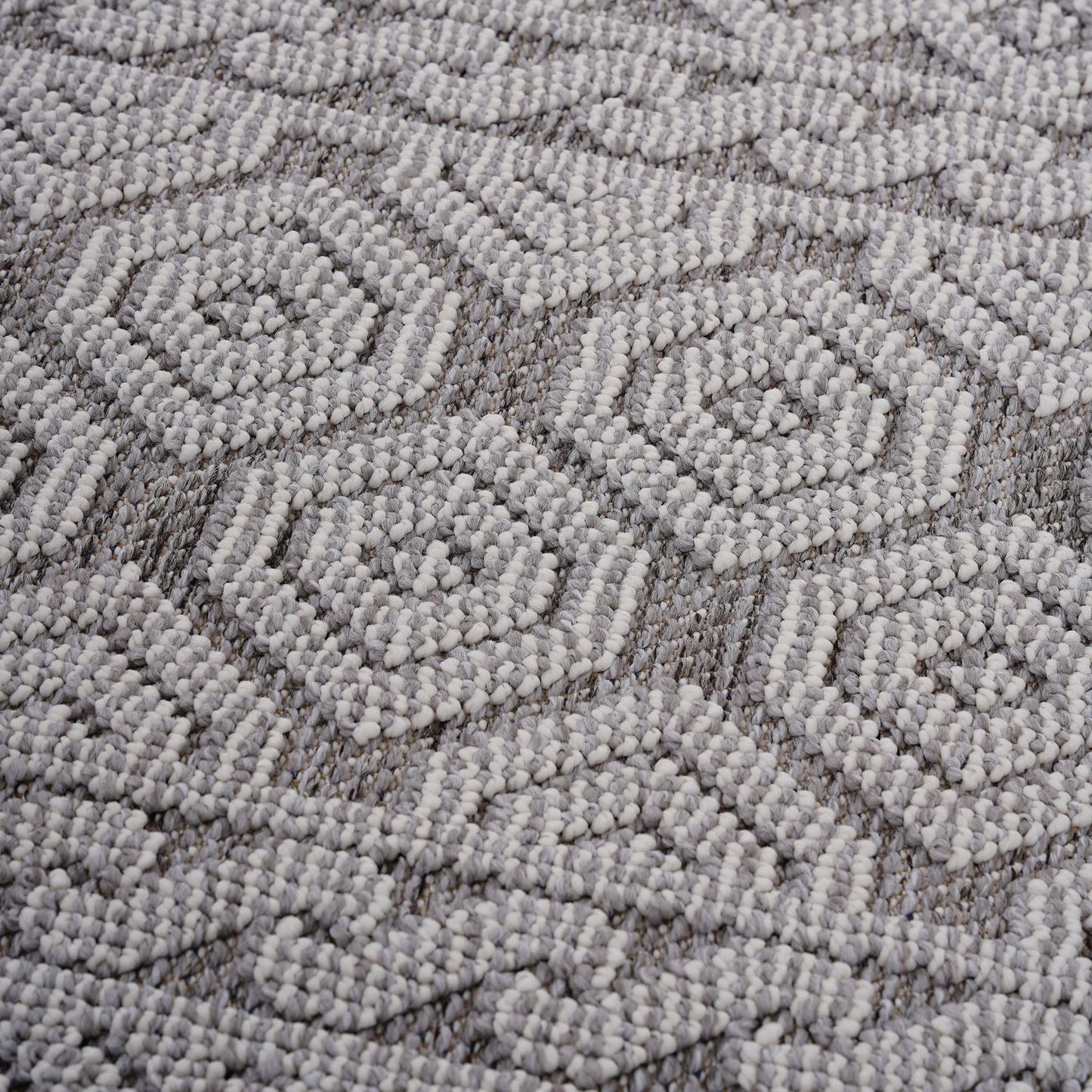 Close-up of a textured gray carpet with a geometric pattern