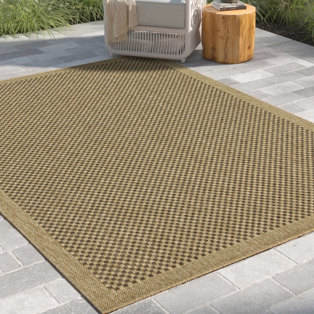 Brown outdoor rug on a patio with a chair and table in the background