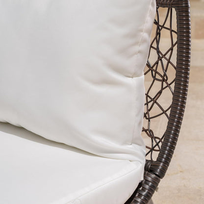 Close-up of a white cushion on a wicker chair with a neutral background