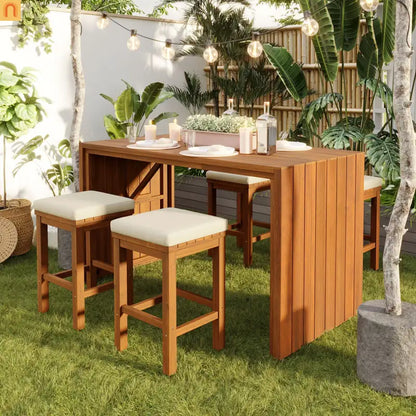 Outdoor wooden dining set with stools on a grassy area with plants and string lights.