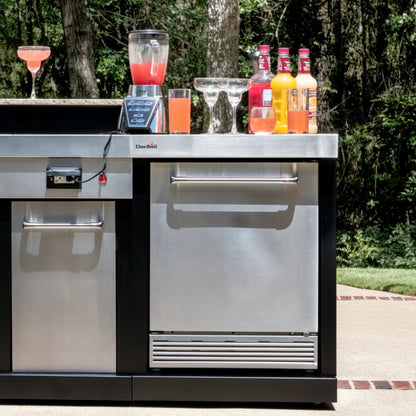 Outdoor kitchen island with drinks and appliances in a backyard setting