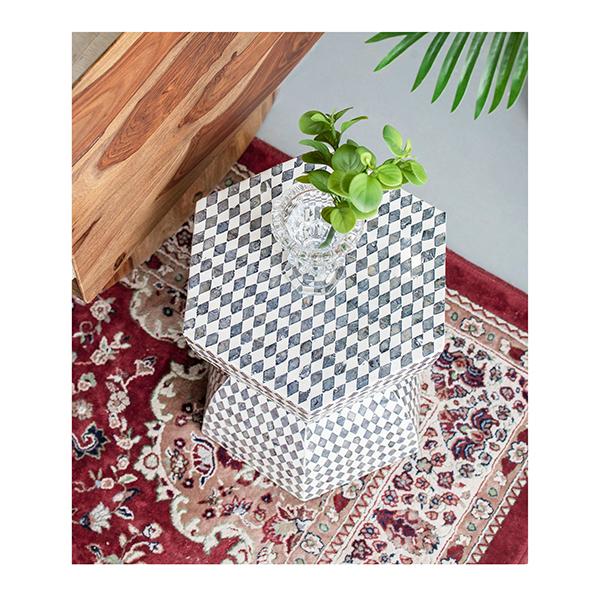 Decorative hexagonal box with a checkered pattern on a floral rug